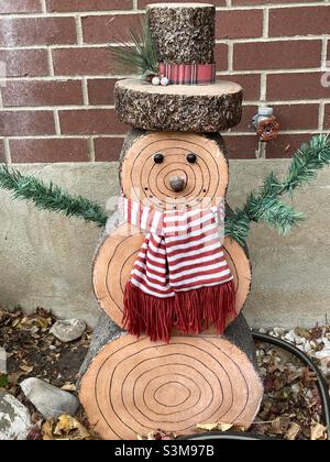 Ein bisschen wie ein einzigartiger Schneemann, dass es aus Schnitten aus dem Stamm einer Kiefer gemacht wird. Aber dieser holzbraune Schneemann lässt, wie andere Schneemänner, immer noch Schneefall zu. Er ist in Erwartung gebündelt. Stockfoto