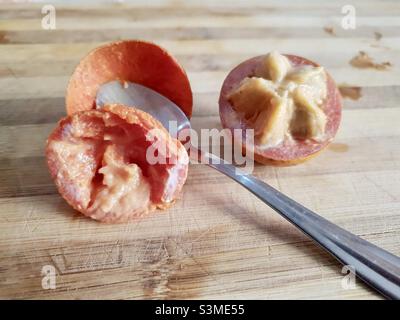 Agbalumo, Alasa oder udara, Afrikanischer Sternapfel, Afrikanische Kirsche, einheimische afrikanische Früchte, Tropische Früchte, Fruchtquerschnitt Stockfoto