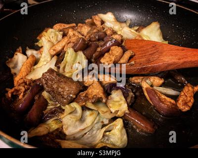 Sautierte Hähnchen mit Auberginen und taiwanesischem Kohl auf einer Pfanne. Stockfoto