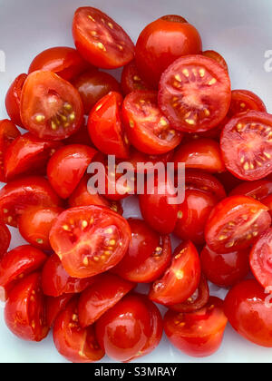 Rote Kirschtomaten in zwei Hälften geschnitten Stockfoto