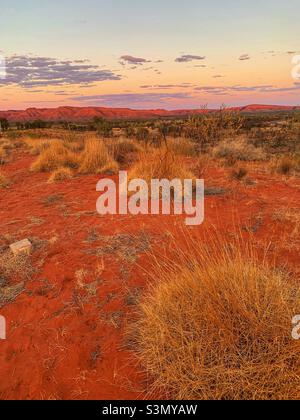 Eine abgelegene Gegend des australischen Outbades mit dem roten Dreck und einem wunderschönen Sonnenuntergang im Hintergrund. Stockfoto