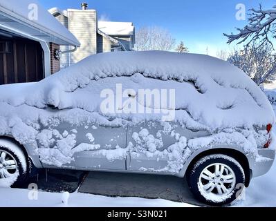 Am Morgen nach einem schweren Schneesturm fällt ein Fuß Schneefall in Utah, USA. Dieser SUV war draußen in der Auffahrt eines Hauses und wird von dem wehenden Schnee aus der Nacht zuvor gehüllt. Stockfoto