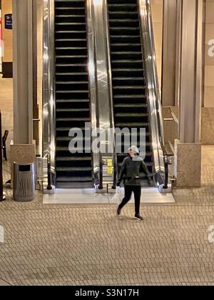 Frau, die im City Creek Center in Salt Lake City, Utah, USA, die Rolltreppe aussteigen muss. Stockfoto