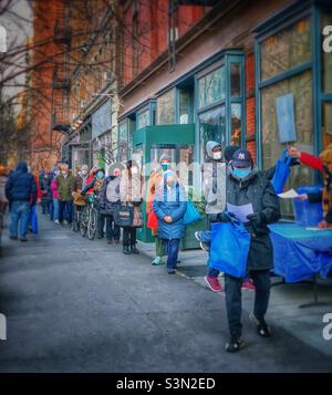 Bewohner stellen sich an, um zu Hause kostenlos COVID-19-Testkit an einem Verteilungsstandort in der Straße 88, Manhattan, New York City, abzuholen. 26. Januar 2022 Stockfoto