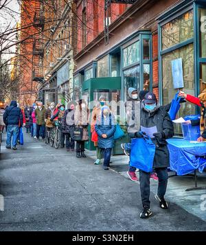 Bewohner stellen sich an, um das COVID-19-Testkit zu Hause an einem Verteilungsstandort zwischen der Straße 88th und 87th in Manhattan, New York City, kostenlos abzuholen. 26. Januar 2022 Stockfoto