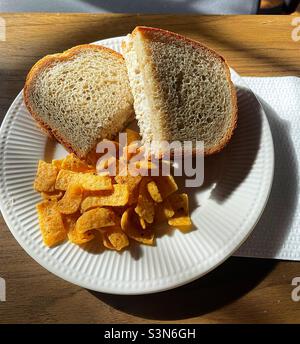 Nahaufnahme eines Mittagessens mit Thunfisch-Fischsalat auf Roggen und Fritos-Maischips auf einem weißen Teller, 2022, USA Stockfoto