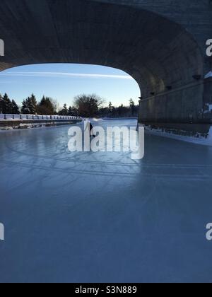 Am frühen Morgen Schlittschuh unter der Bank Street Brücke auf dem Rideau Kanal in Ottawa, Kanada. Stockfoto