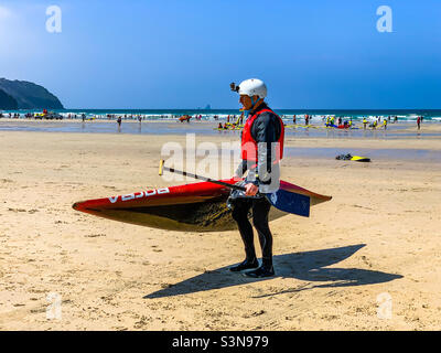 Surfer gehen am Strand mit Surfbrett Stockfoto