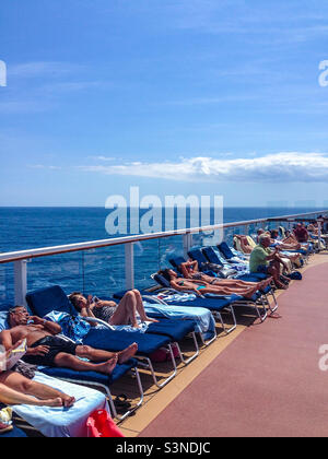 Passagiere, die im Sommer auf einem Schiff im Mittelmeer sonnenbaden Stockfoto