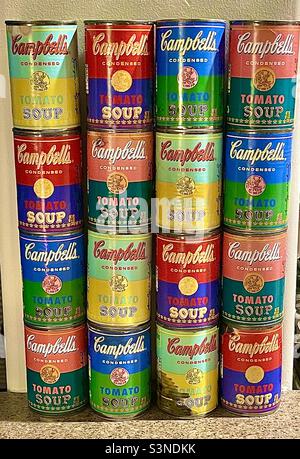 Eine etwas abgenutzte Sammlung/Ausstellung von einem Dutzend Campbell-Suppendosen im Warhol-Stil, ungeöffnet und mit Suppe gefüllt. Die Dosen wurden speziell als Warhol-Erinnerungsstücke aus der Popkunst gemustert und verkauft Stockfoto