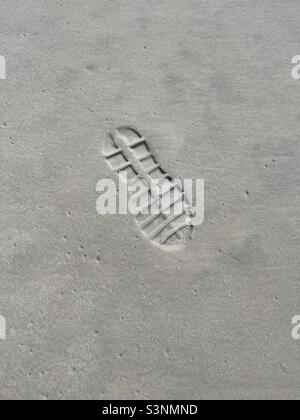 Detaillierter Schuhaufdruck auf Strandsand Stockfoto