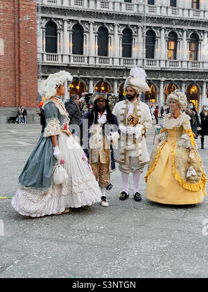 Menschen, die während der Karnevalsfeiern auf dem Markusplatz in Venedig Italien in historischen Kostümen gekleidet waren. Februar 2022. Stockfoto