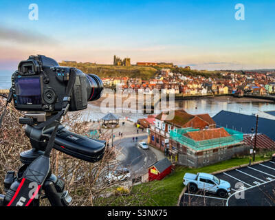 Professioneller Fotograf, der in der Abenddämmerung mit einer digitalen spiegelreflexkamera von Whitby fotografiert Stockfoto