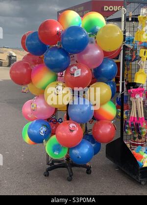 Helle, bunte Strandbälle zum Verkauf am Meer in Southend. Stockfoto