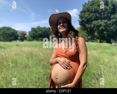 8 Monate schwanger Frau hält ihren Bauch. Linea nigra sichtbar Stockfoto