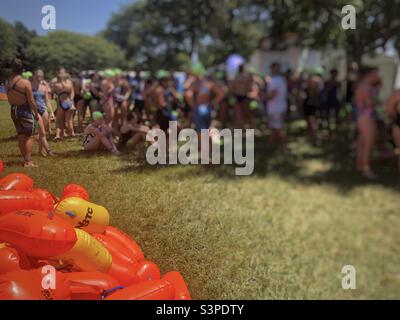 Schwimmerinnen warten auf das Schwimmen in der jährlichen Midmar Mile 2022 mit orangefarbenen Safe-Schwimmerbojen im Vordergrund Stockfoto