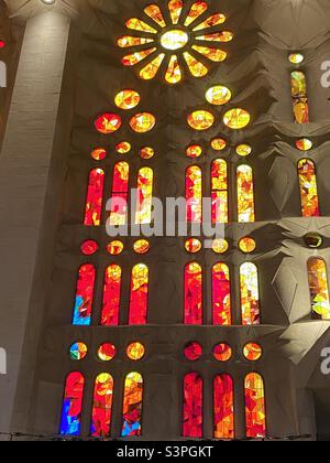 Buntglasfenster, das den Sonnenuntergang an der Basílica de la Sagrada Família, Barcelona, Katalonien, Spanien, Europa darstellt. März 2022. Stockfoto