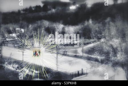 Eine Familie spaziert an einem schönen Frühlingstag gemeinsam durch den Memory Grove Memorial Park in Salt Lake City, Utah. Ein breiter, weicher Fokus, entsättigte Ansicht des Parks steht im Kontrast zu den hervorgehobenen Spaziergängern. Stockfoto