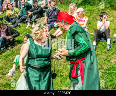 Ein Paar in Kostümen holt sich einen schnellen Happen zum Essen bei den traditionellen Hastings Jack in the Green Festlichkeiten. Großbritannien, Mai 2008 Stockfoto