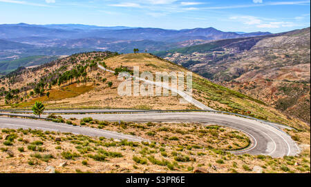 Eine Straße schlängelt sich durch die hügelige Landschaft in der Nähe des Nationalparks Serra Da Estrela, Portugal Okt 2019 Stockfoto