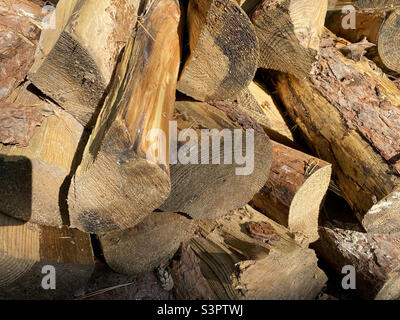 Hintergrund von gehacktem Holz, das übereinander liegt. Stapel von abgebrochtenem Holz in Nahaufnahme Stockfoto