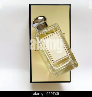 Eine Flasche Parfüm aus einer gelben Schachtel auf einem weißen, isolierten Hintergrund Stockfoto