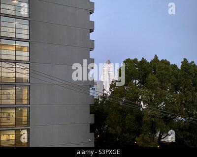 LOS ANGELES, CA, APR 2021: Blick über Vordergrundwohnungen zum Rathaus, das in der Ferne rosa leuchtet, Downtown, Abenddämmerung Stockfoto