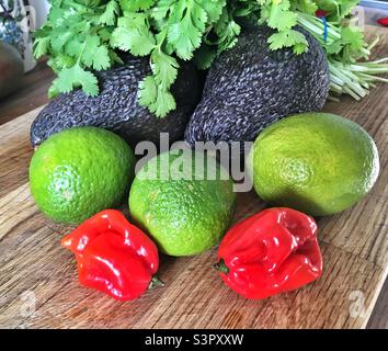 Scotch Bonnet Chilis, Limetten, Avocados und Koriander, um einen Guacamol-Dip zu machen Stockfoto