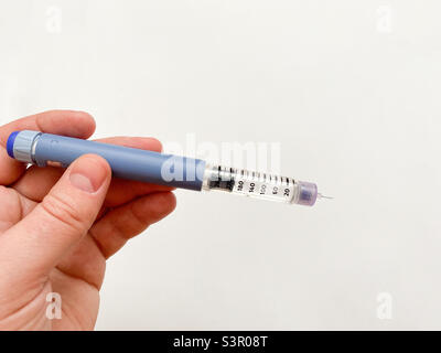 Insulinspritze-Stift in der Hand auf weißem, isoliertem Hintergrund. Insulin für Diabetiker Stockfoto