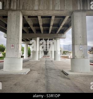 Betonsäulen, die eine Straße über dem Kopf in Los Angeles, Kalifornien, mit Bergen in der Ferne stützen. Bewölktes Wetter Stockfoto