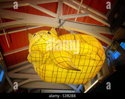 Eine beleuchtete Skulptur der Kätzin von Alice im Wunderland, die auf dem überdachten Markt in Oxford, Großbritannien, hängt. Stockfoto