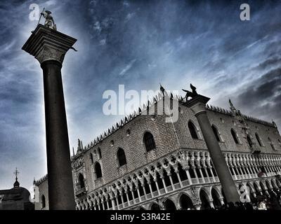 Ungewöhnliche Perspektive in dramatischem Licht von San Marco mit den Säulen von San Marco und San Todaro, Venedig, Italien. Colonna di San Marco e San Teodoro, Piazza San Marco, Venezia, Italia. Stockfoto