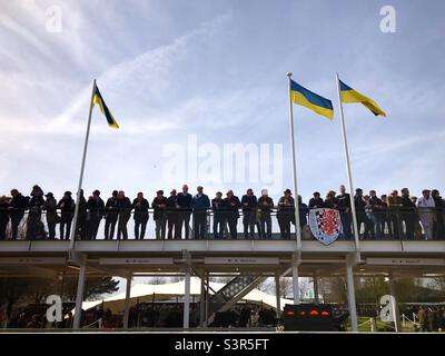 Goodwood steht mit der Ukraine, Zuschauer stehen über der Box beim Mitgliedertreffen 79. mit fliegenden ukrainischen Flaggen. Stockfoto