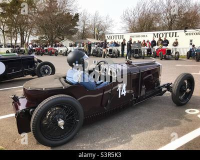 Eine Frau, die in ihrem Frazer Nash-Rennwagen im Versammlungsbereich von Goodwood für die Mitgliederversammlung 79. sitzt. Stockfoto