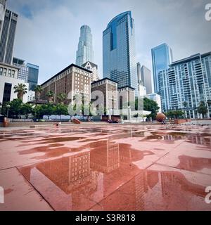 LOS ANGELES, CA, 2021. JULI: Blick auf das Biltmore Hotel und die umliegenden Gebäude mit Reflexionen, vom Pershing Square in der Innenstadt aus gesehen, nach Regen. Quadratisches Erntegut Stockfoto