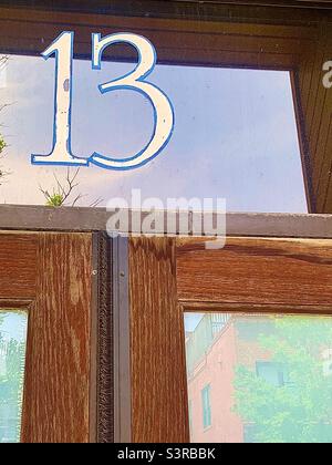 Braune Holztüren mit der Nummer 13 am Heckspiegel Stockfoto