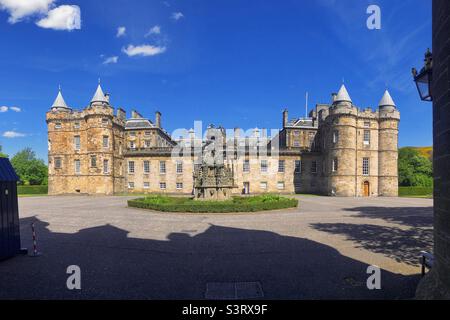 Palace of Holyroodhouse oder Holyrood Palace am Ende der Royal Mile, Canongate, Edinburgh, Schottland an einem sonnigen Tag mit blauem Himmel. Die offizielle Residenz des britischen Monarchen in Schottland. Stockfoto