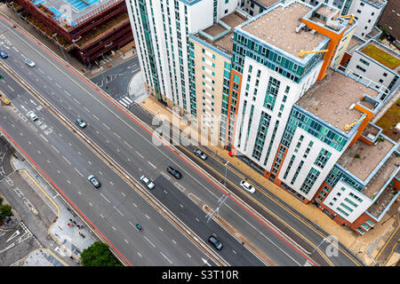Blick von oben auf farbenfrohe und lebendige Wohnblocks mit Straßen, die in eine große Stadt führen Stockfoto