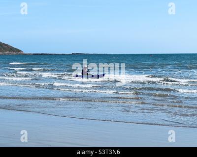 Mann paddelt mit einem kleinen Boot in seichtem Wasser Stockfoto