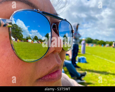 Reflexionen in den Gläsern einer Sonnenbrille, die von einer asiatischen Dame getragen wird. Stockfoto