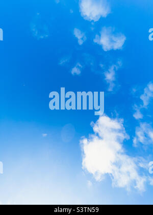 Blauer Himmel mit verstreuten weißen Wolken an einem sonnigen Sommertag. Stockfoto