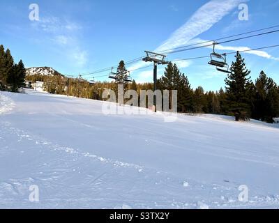 Leere Sessellifte über Anfängerpisten im Ski- und Snowboardgebiet Mammoth Mountain in Kalifornien. Blauer Himmel über dem Himmel Stockfoto