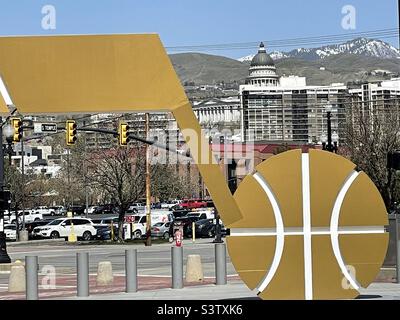 Großes Utah Jazz Basketball-Logo vor der Vivint Arena, der Heimat des Utah Jazz in SLC, Utah, USA. Hinter dem Logo sehen Sie einen Teil der Innenstadt und das State Capitol. Stockfoto