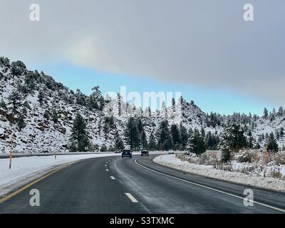 Autos, die vom Skigebiet Mammoth in den Süden fahren, auf verschneiten, nassen Autobahnen, US Route 395, Mammoth Lakes, Kalifornien Stockfoto