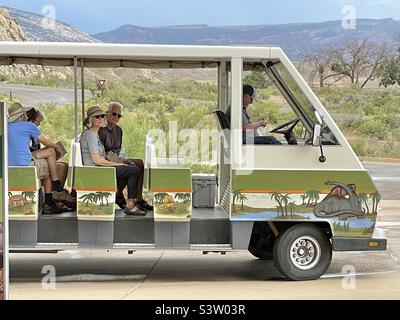 Der Shuttle am Dinosaur National Monument in Vernal, Utah, USA, bringt Besucher vom Besucherzentrum aus, das eine kurze Strecke bergauf zum Steinbruch oder zur Ausgrabung führt, wo die Fossilien und Knochen auf sie warten. Stockfoto