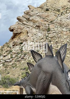Beim Betreten des Besucherzentrums am Dinosaur National Monument in Vernal, Ut., USA, begrüßt diese Dinosaurierstatue die Besucher. Komischerweise sehen die Flossen auf dem Rücken wie die zerklüfteten Felsen dahinter aus Stockfoto