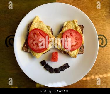 Frühstück mit Smiley auf weißem Teller Stockfoto