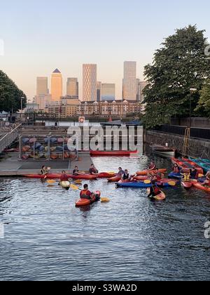 Kajakfahren im shadwell-Becken mit Canary Wharf im Hintergrund Stockfoto