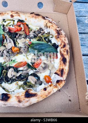 Traditionelle italienische Pizza in einer Schachtel. Wilder Brokkoli und Pilze, Tomaten und Basilikum mit Ricotta gefüllter Kruste. Stockfoto