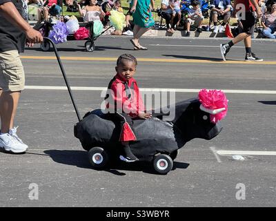 6. August 2022 Ein kleiner Junge reitet auf einem Spielzeugbullen bei der Kinderparade ‘Old Spanish Days’ Fiesta in Santa Barbara, Kalifornien, USA Stockfoto